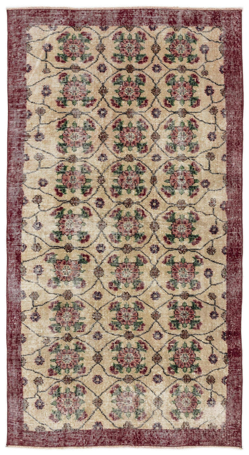 Load image 1 in gallery view. Beige rug with a red border and a repeating floral medallion pattern in red and green, featuring a distressed finish.