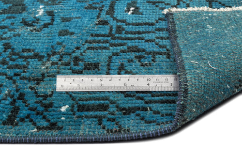Load image 1 in gallery view. Teal and black distressed patterned rug with a folded corner and a stainless steel ruler for scale.