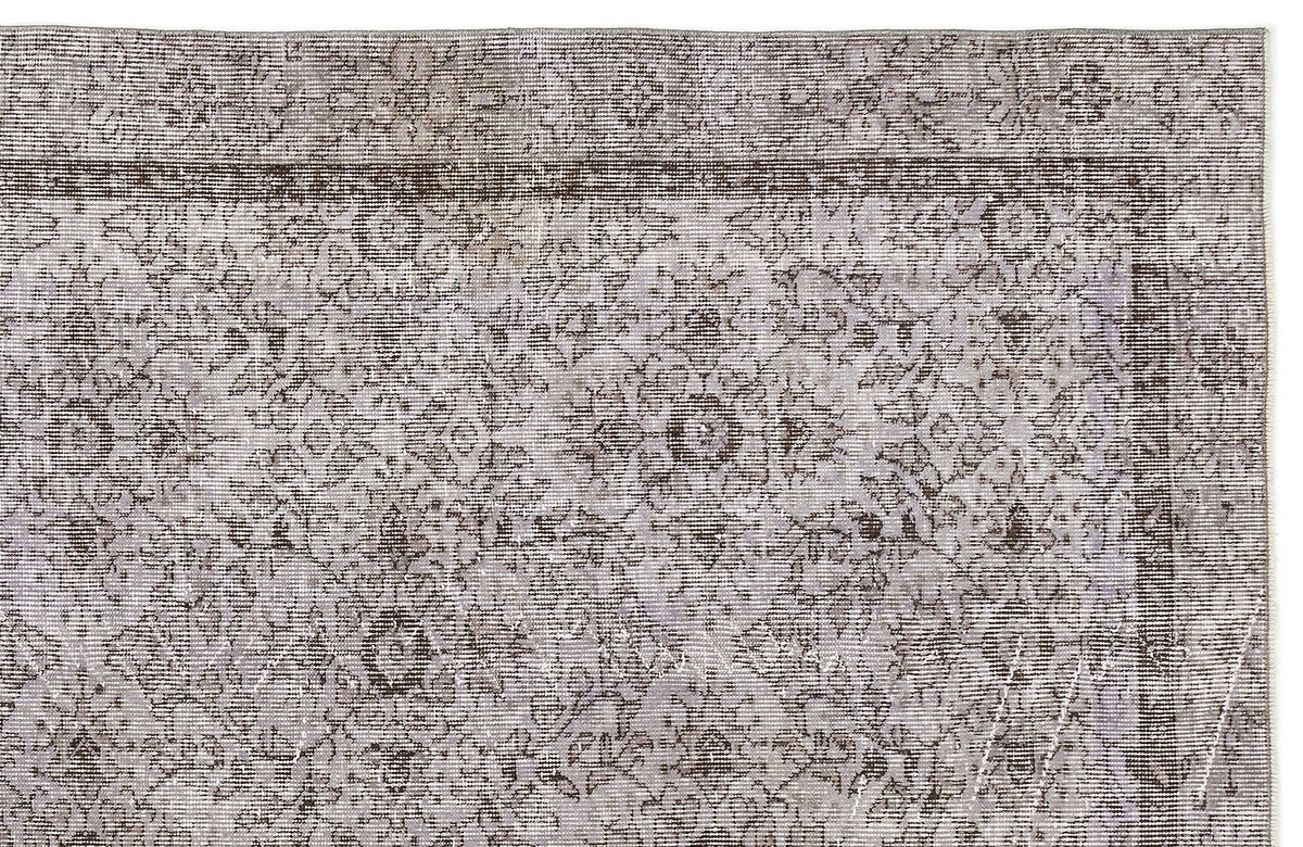 Grey and brown distressed rug with a traditional floral medallion pattern and a bordered edge.