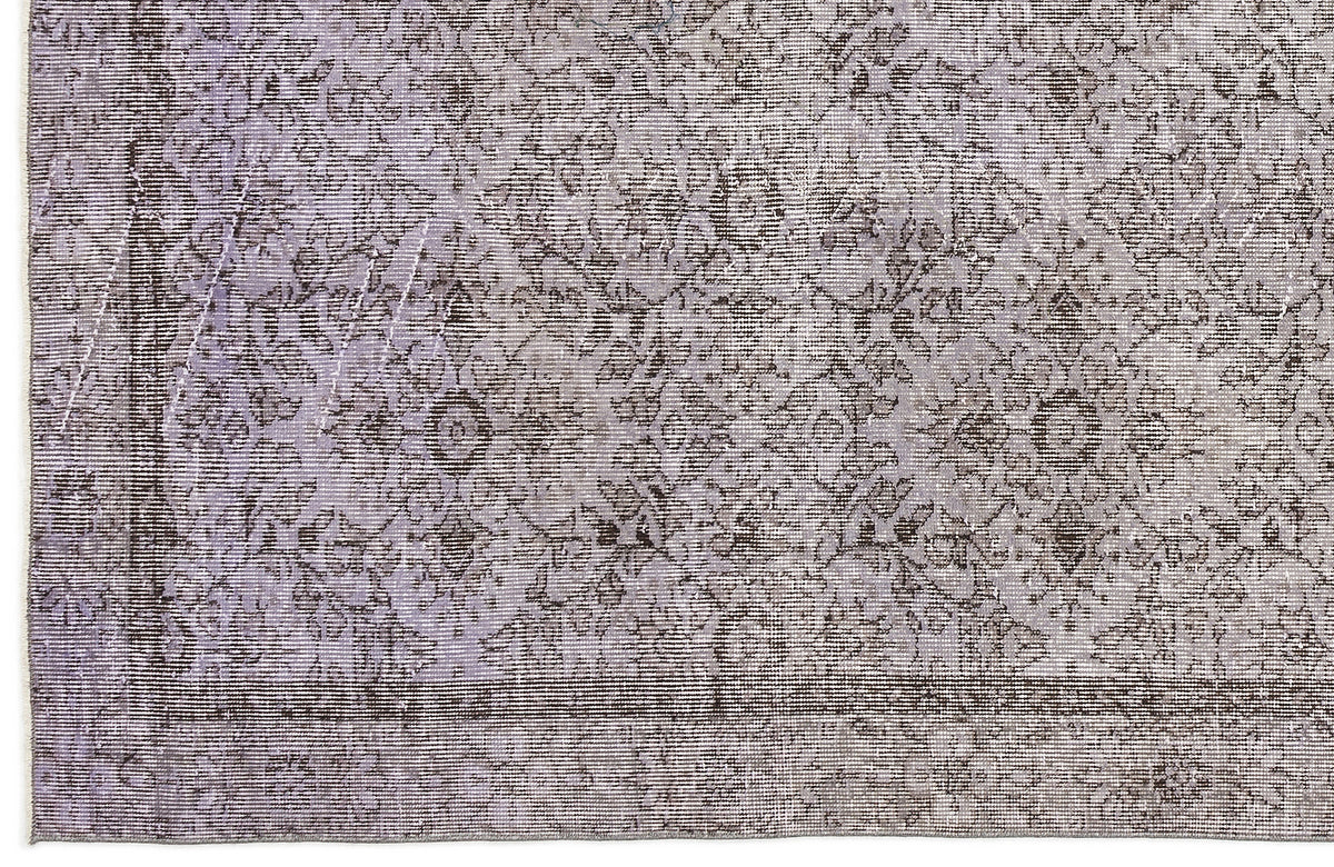 Lavender and charcoal grey rug with a distressed, traditional floral medallion pattern and a bordered edge.
