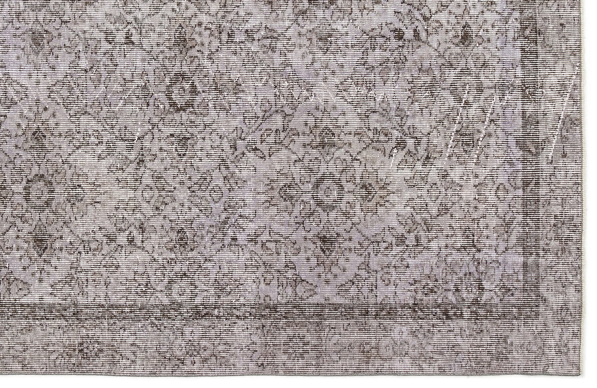 Grey and charcoal distressed rug with a traditional floral medallion pattern and a bordered edge.
