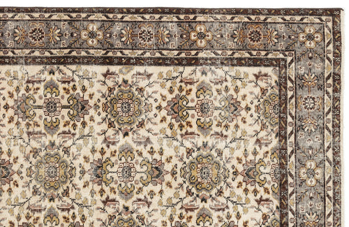 Load image 1 in gallery view. Cream rug with a traditional floral medallion pattern in brown, grey, and muted gold, featuring a detailed border.