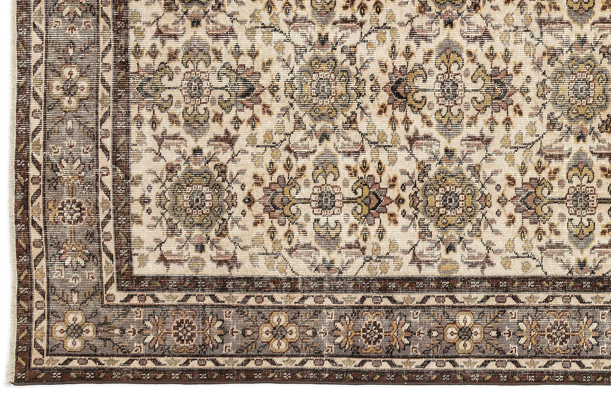 Cream rug with a traditional floral medallion pattern in brown, olive, and grey, featuring a detailed geometric border.