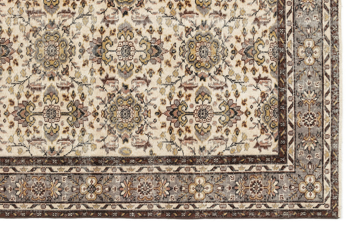 Cream rug with a traditional floral medallion pattern in brown, grey, and gold, featuring a detailed geometric border.