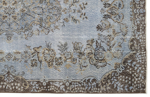 Load image 1 in gallery view. Light blue and brown distressed rug with a traditional floral medallion pattern and a dark border.
