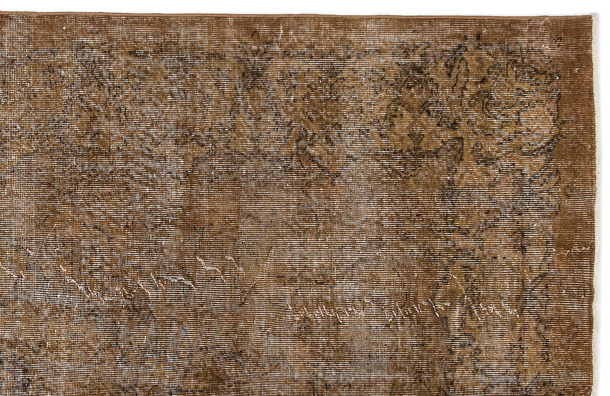 Distressed brown rug with a faded traditional floral medallion pattern on a white background.
