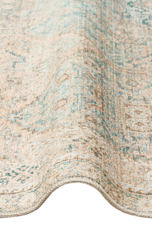 Load image 1 in gallery view. Beige and teal distressed traditional medallion rug with a folded edge on a white background.
