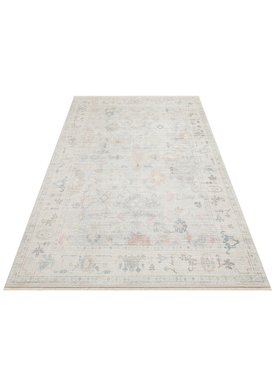 Light gray area rug with a faded traditional floral medallion pattern in muted blue, pink, and beige tones.