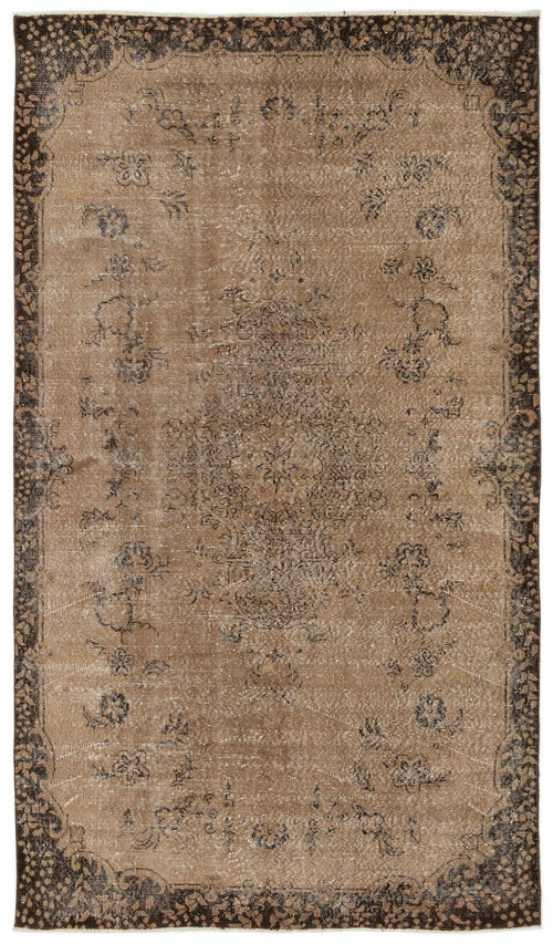 Load image 1 in gallery view. Distressed brown and dark charcoal rug with a central floral medallion and a wide, ornate botanical border.