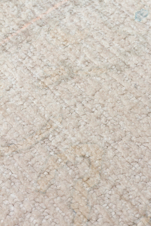 Bild 1 in Galerieansicht laden. Close-up of a high-pile beige rug with subtle, faded grey and light blue abstract patterns.