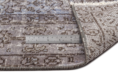 Load image 1 in gallery view. Blue and brown distressed traditional rug with a folded corner and a metal ruler for scale on a white background.