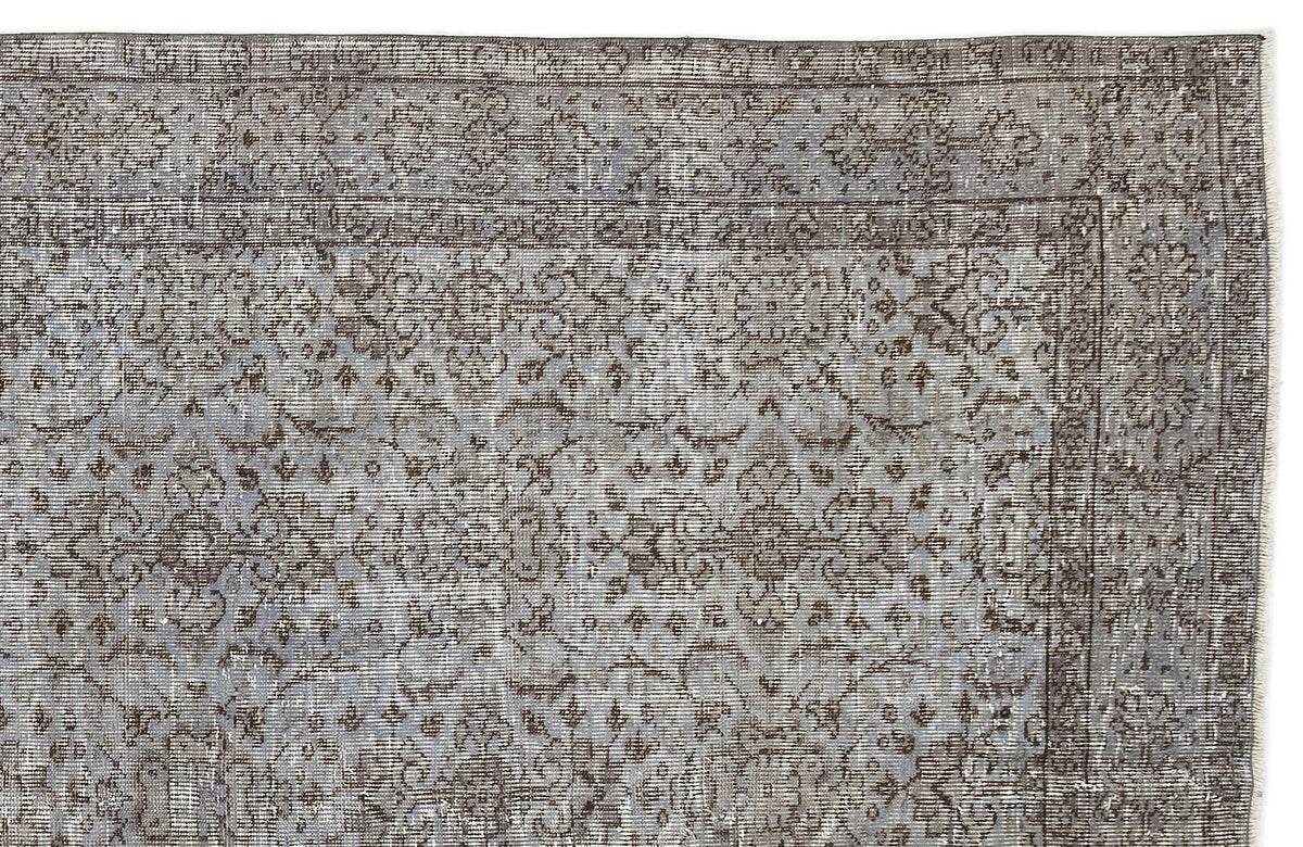 Grey and charcoal distressed rug with a traditional floral medallion pattern and a bordered edge.