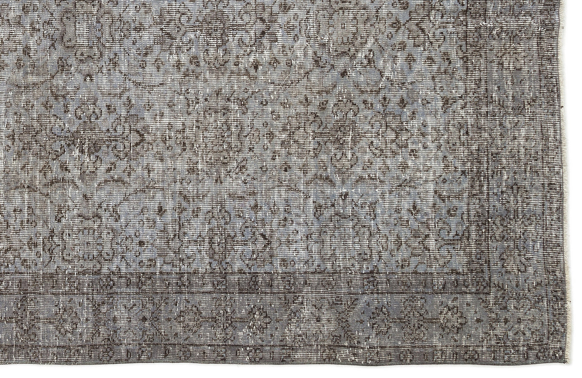 Grey and charcoal distressed rug with a faded traditional floral medallion pattern and a bordered edge.