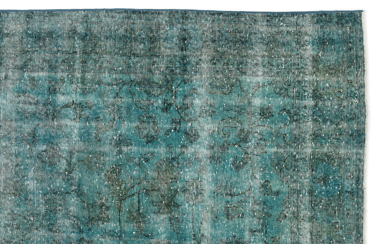 Teal and dark blue distressed rug with a faded, intricate floral medallion pattern on a white background.