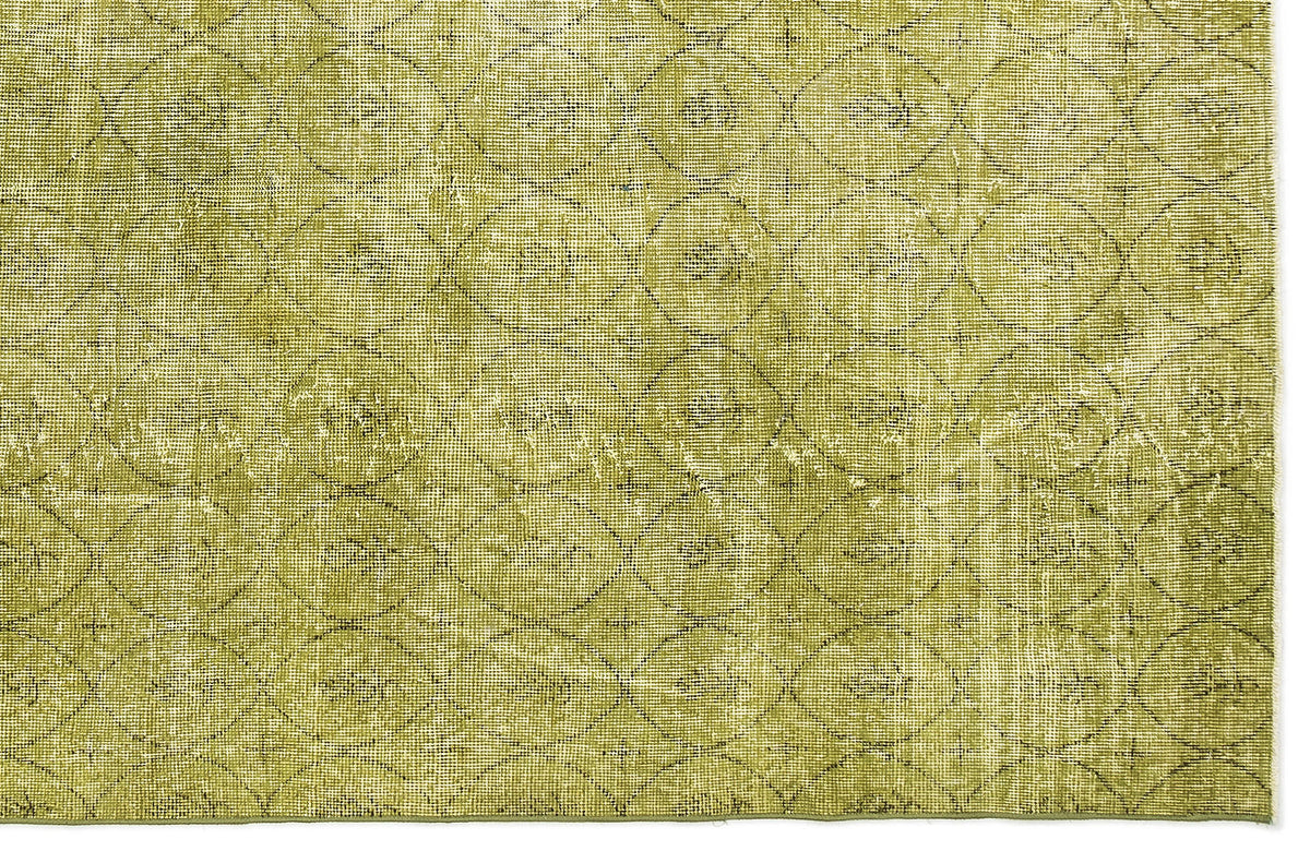 Olive green distressed rug with a repeating dark geometric circle and diamond pattern.