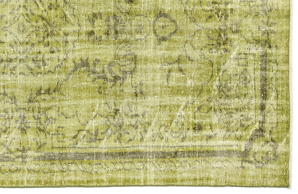 Chartreuse and olive green rug with a distressed, faded traditional floral medallion pattern.