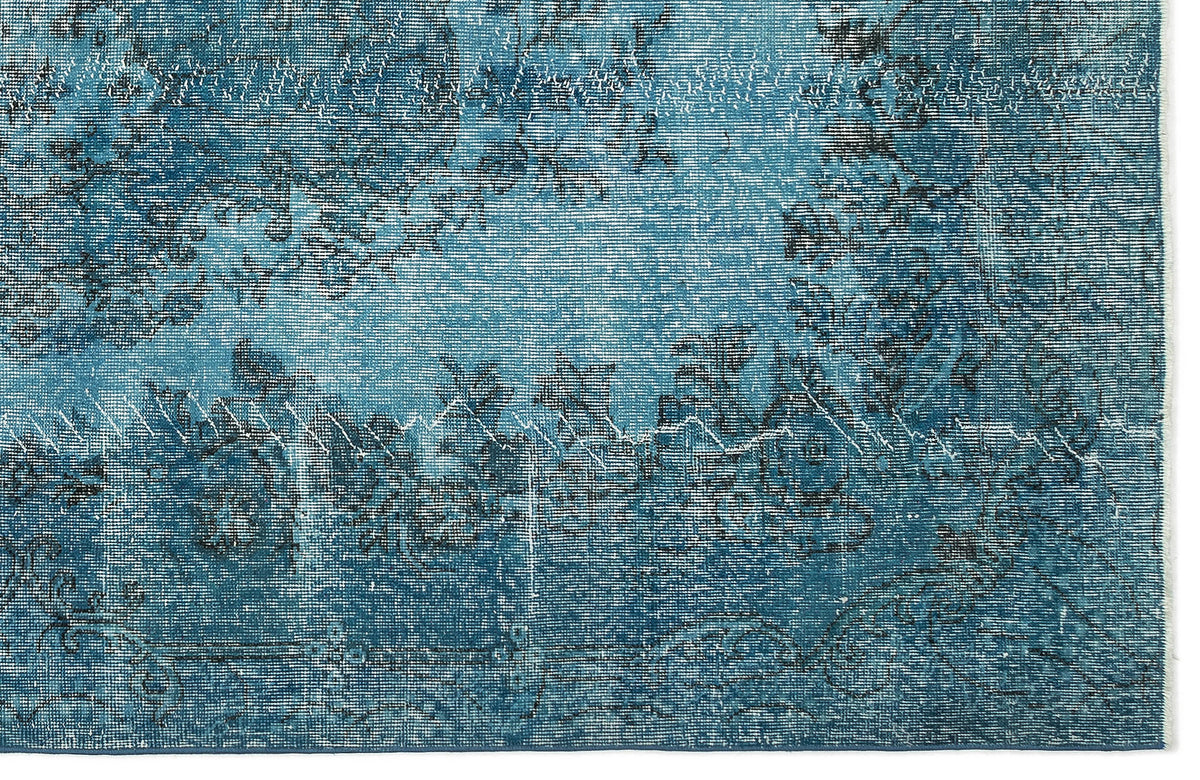 Teal and black distressed rug with a faded traditional floral medallion pattern.