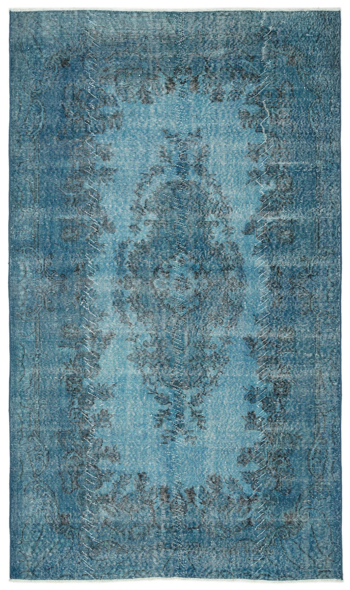 Distressed teal and blue rug with a faded central medallion and floral border pattern.