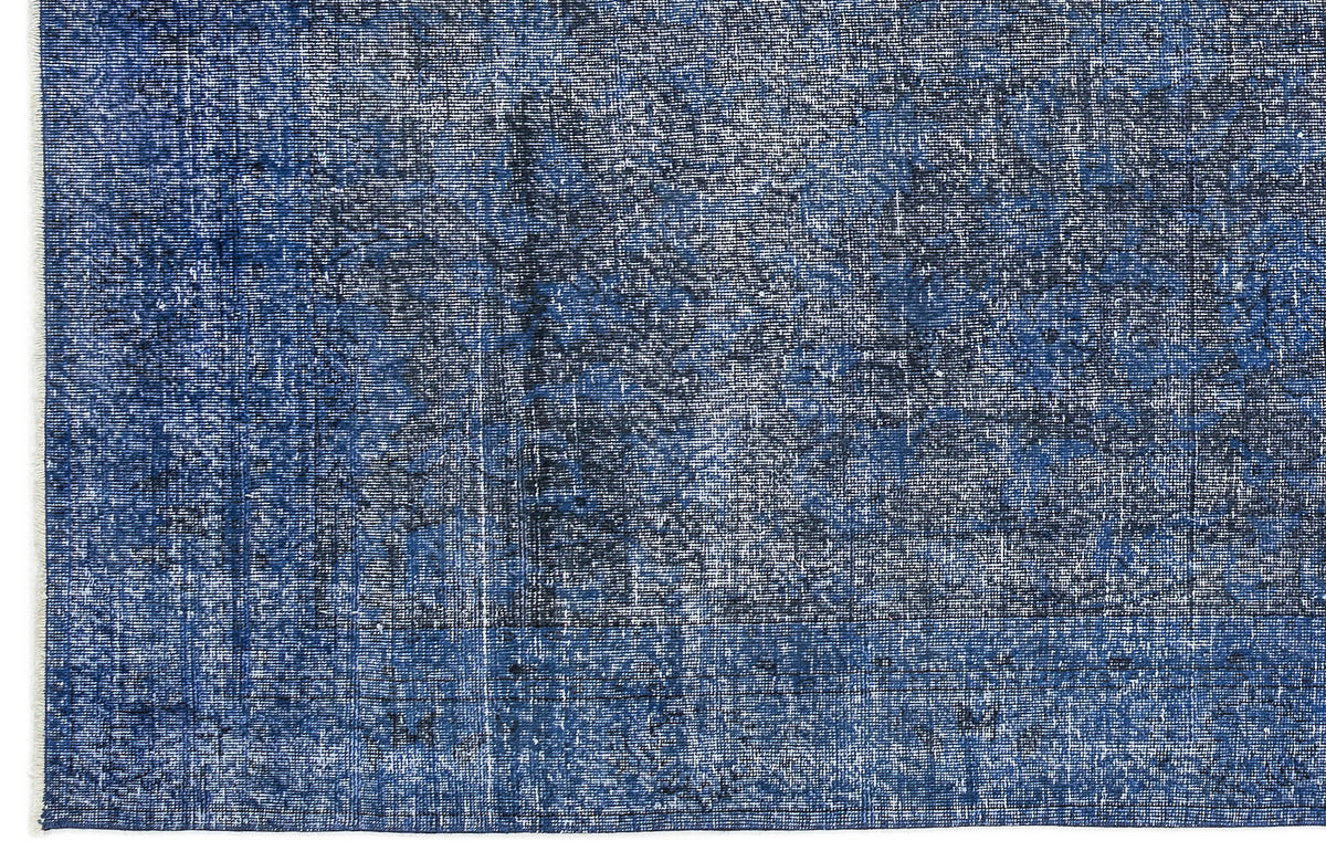 Navy and white distressed rug with a faded traditional medallion pattern and fringed edge.