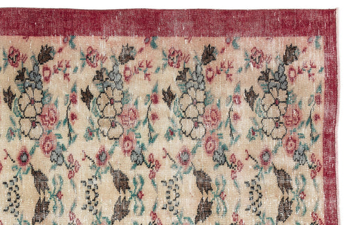 Load image 1 in gallery view. Beige rug with a distressed floral pattern in red, teal, and charcoal, featuring a solid red border.