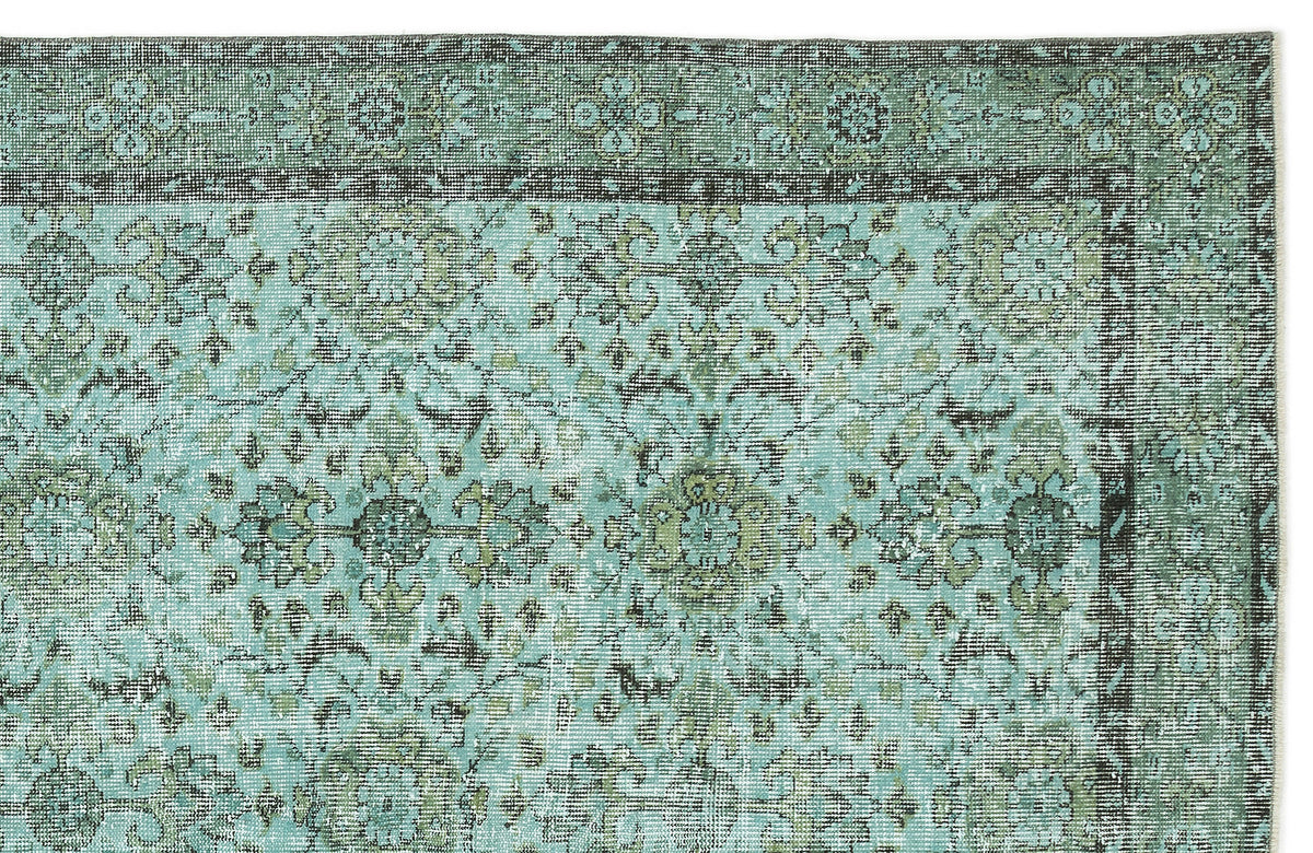 Distressed teal and olive green rug with a traditional floral medallion pattern and a dark border.