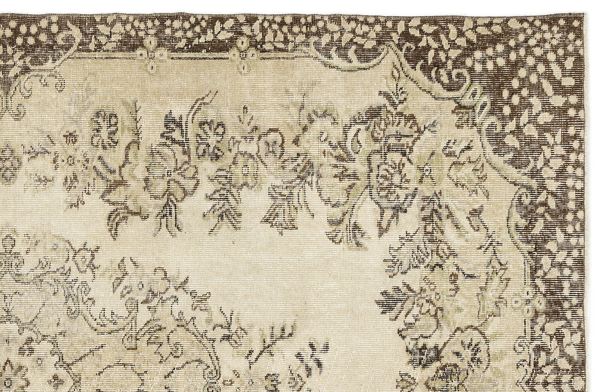 A section of the Coveis Vintage Medallion Rug (5'10 x 9'4) displays a faded floral and decorative border in muted beige and brown, trimmed with intricate leaf and dot detailing that captures the timeless Anatolian style.