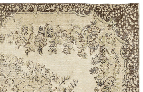 Load image 1 in gallery view. A section of the Coveis Vintage Medallion Rug (5'10 x 9'4) displays a faded floral and decorative border in muted beige and brown, trimmed with intricate leaf and dot detailing that captures the timeless Anatolian style.