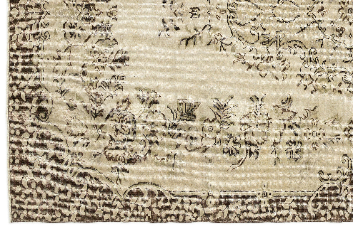 A close-up of the Coveis - Vintage Medallion Rug (5'10 x 9'4) shows detailed floral and vine patterns on a beige and brown border, with muted colors that create an antique, vintage look and highlight its timeless charm.