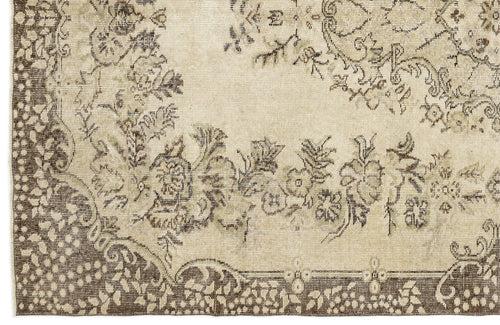 Load image 1 in gallery view. A close-up of the Coveis - Vintage Medallion Rug (5'10 x 9'4) shows detailed floral and vine patterns on a beige and brown border, with muted colors that create an antique, vintage look and highlight its timeless charm.