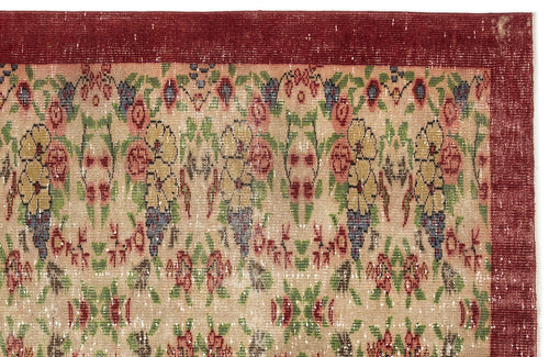 Load image 1 in gallery view. Distressed beige rug with a deep red border and a repeating floral pattern in red, yellow, green, and blue.