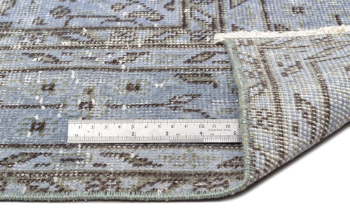 Load image 1 in gallery view. Blue and grey distressed traditional rug with a geometric border and fringe, shown with a metal ruler for scale.