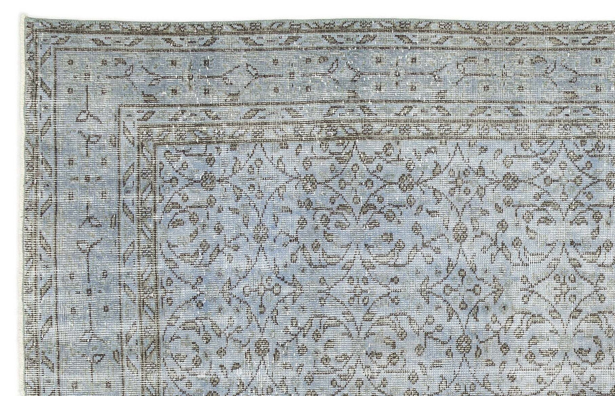 Light blue and taupe traditional rug with a distressed floral vine pattern and a multi-layered border.