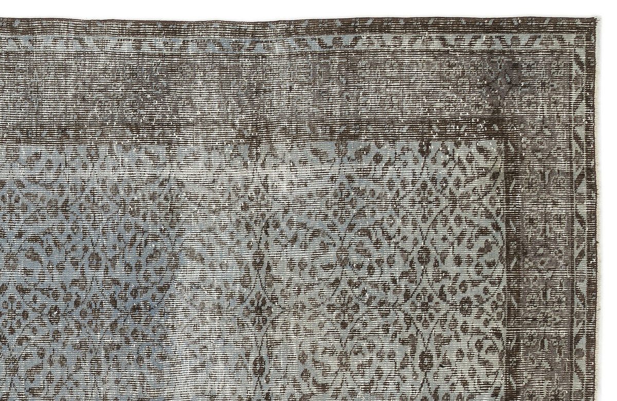 Charcoal and slate blue distressed rug with a traditional ornate medallion pattern and a geometric border.