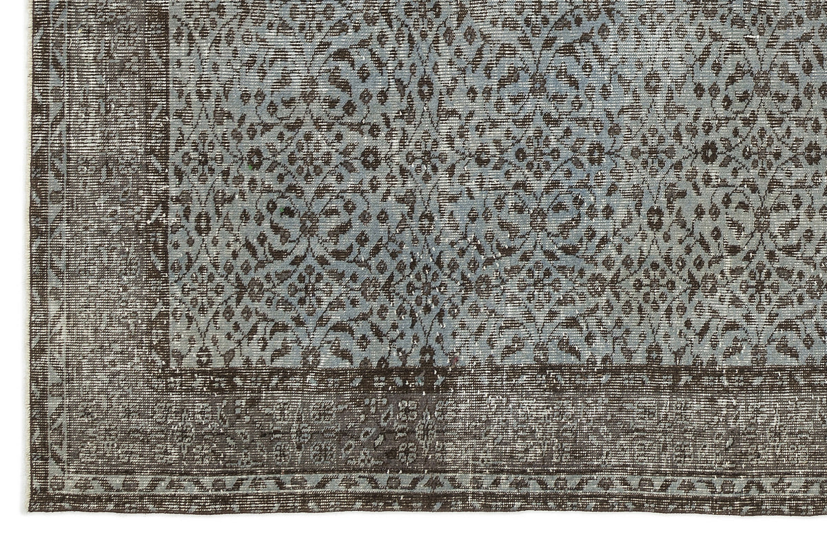Distressed slate blue and dark brown rug with an intricate floral medallion pattern and a wide decorative border.