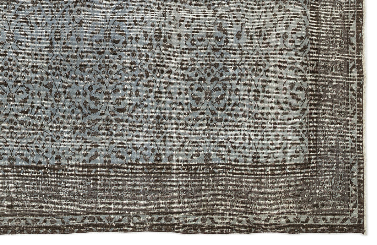 Blue and charcoal grey rug with a distressed, traditional floral medallion pattern and a wide decorative border.