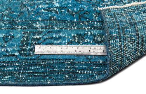 Load image 1 in gallery view. Teal and black distressed traditional rug with a folded corner and a metal ruler for scale on a white background.