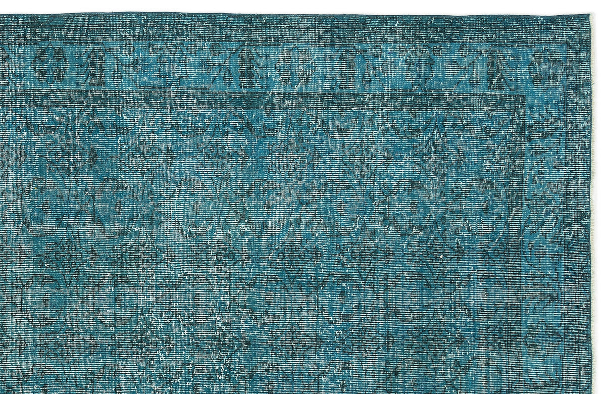 Teal and dark blue distressed rug with a traditional ornate border and faded floral medallion pattern.