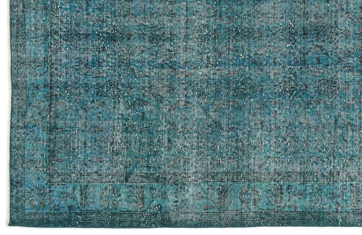 Teal and dark blue distressed rug with a faded traditional medallion pattern and a bordered edge.