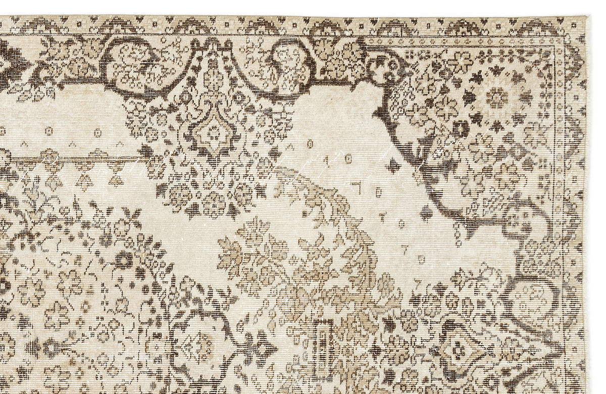 Beige and dark brown rug with a distressed traditional floral medallion pattern.