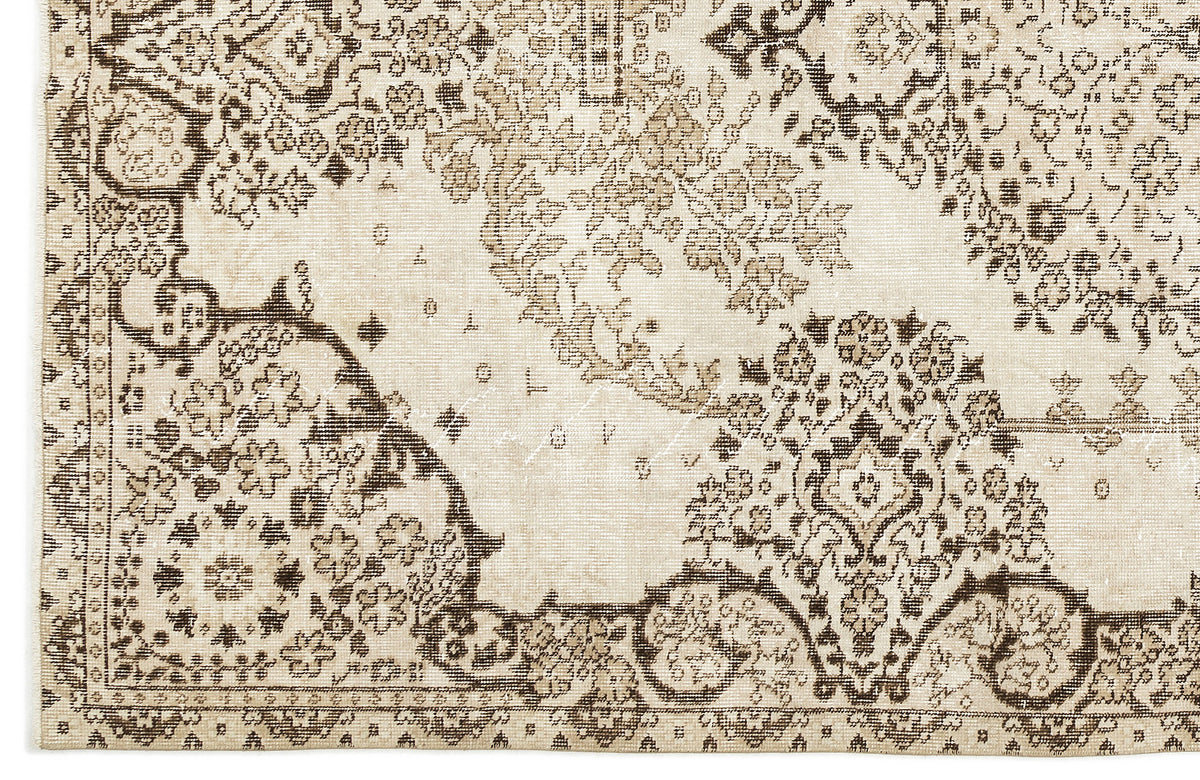 Beige and dark brown traditional rug with a distressed floral medallion pattern.