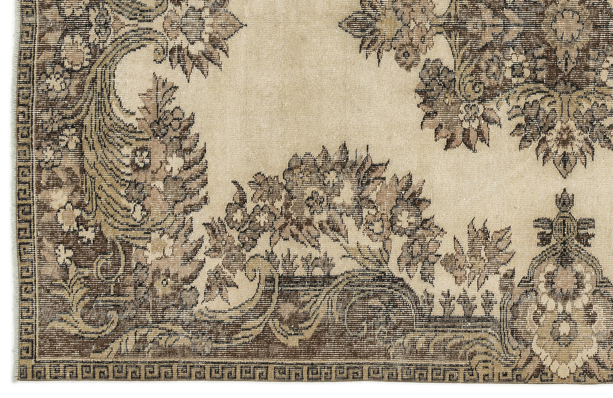 Beige and brown traditional rug with a distressed floral pattern and a geometric border.