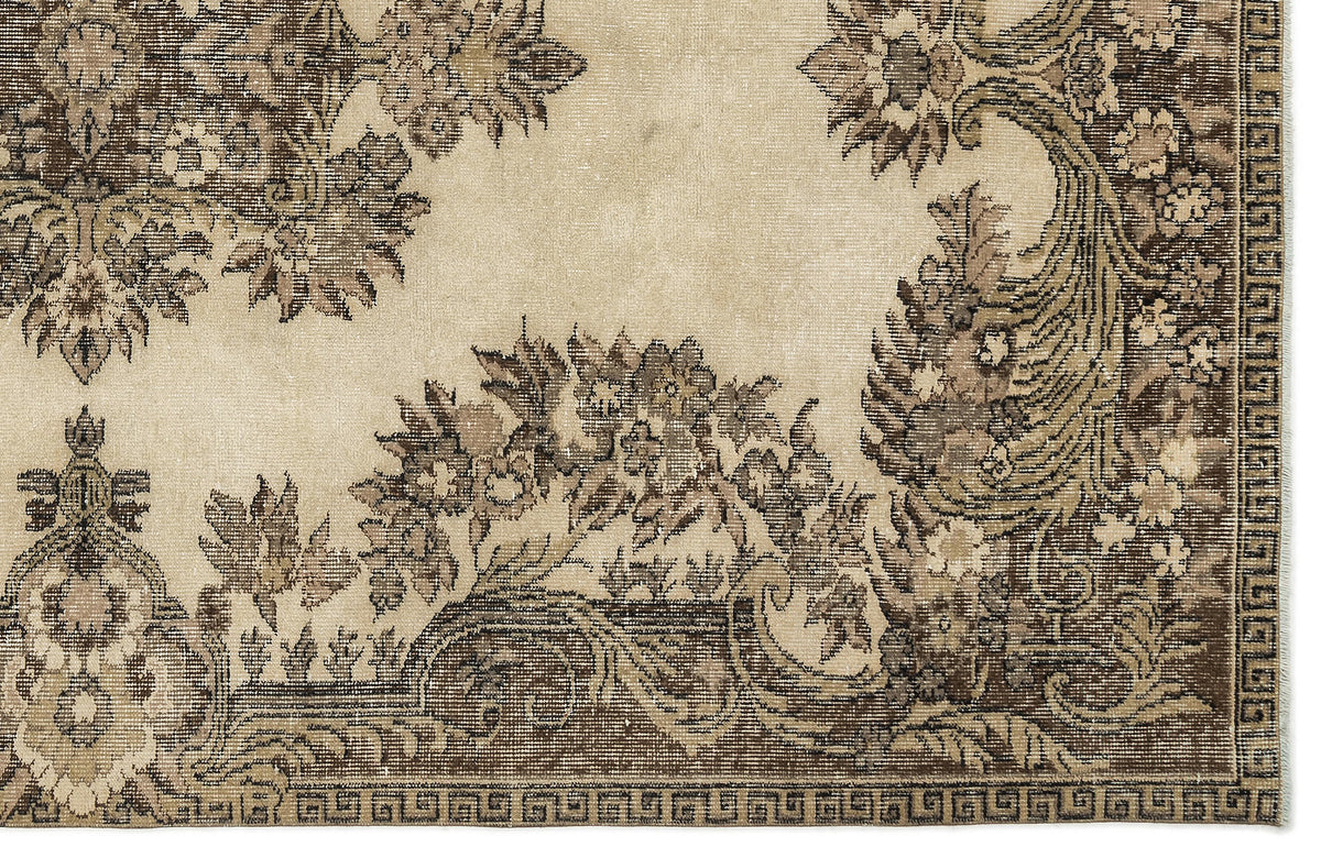 Beige and brown vintage-style rug with a distressed floral medallion pattern and a geometric border.