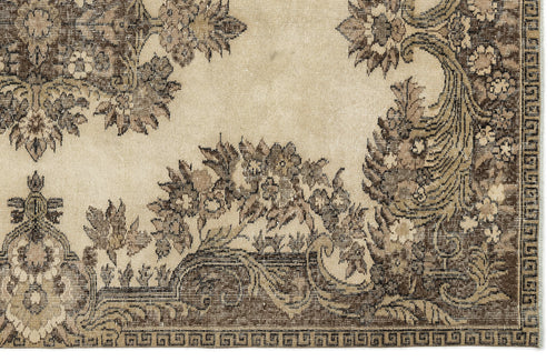 Load image 1 in gallery view. Beige and brown vintage-style rug with a distressed floral medallion pattern and a geometric border.