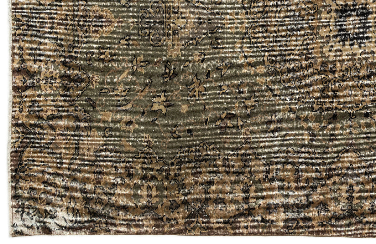 Distressed olive green and brown rug with a traditional floral medallion pattern and faded, worn texture.