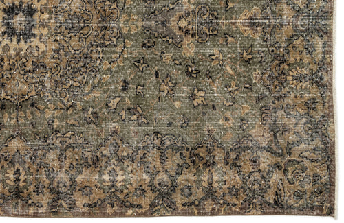 Load image 1 in gallery view. Distressed olive green and brown rug with a faded traditional floral medallion pattern and a fringed edge.