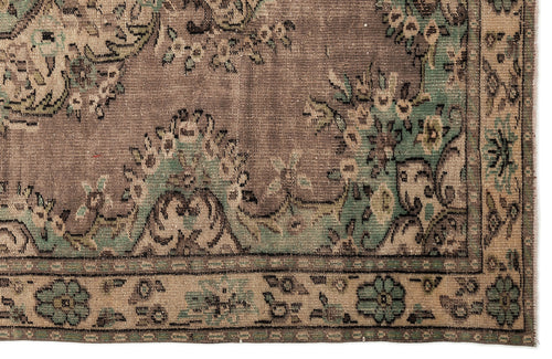 Load image 1 in gallery view. Distressed brown and sage green rug with a traditional floral medallion pattern and a decorative border.