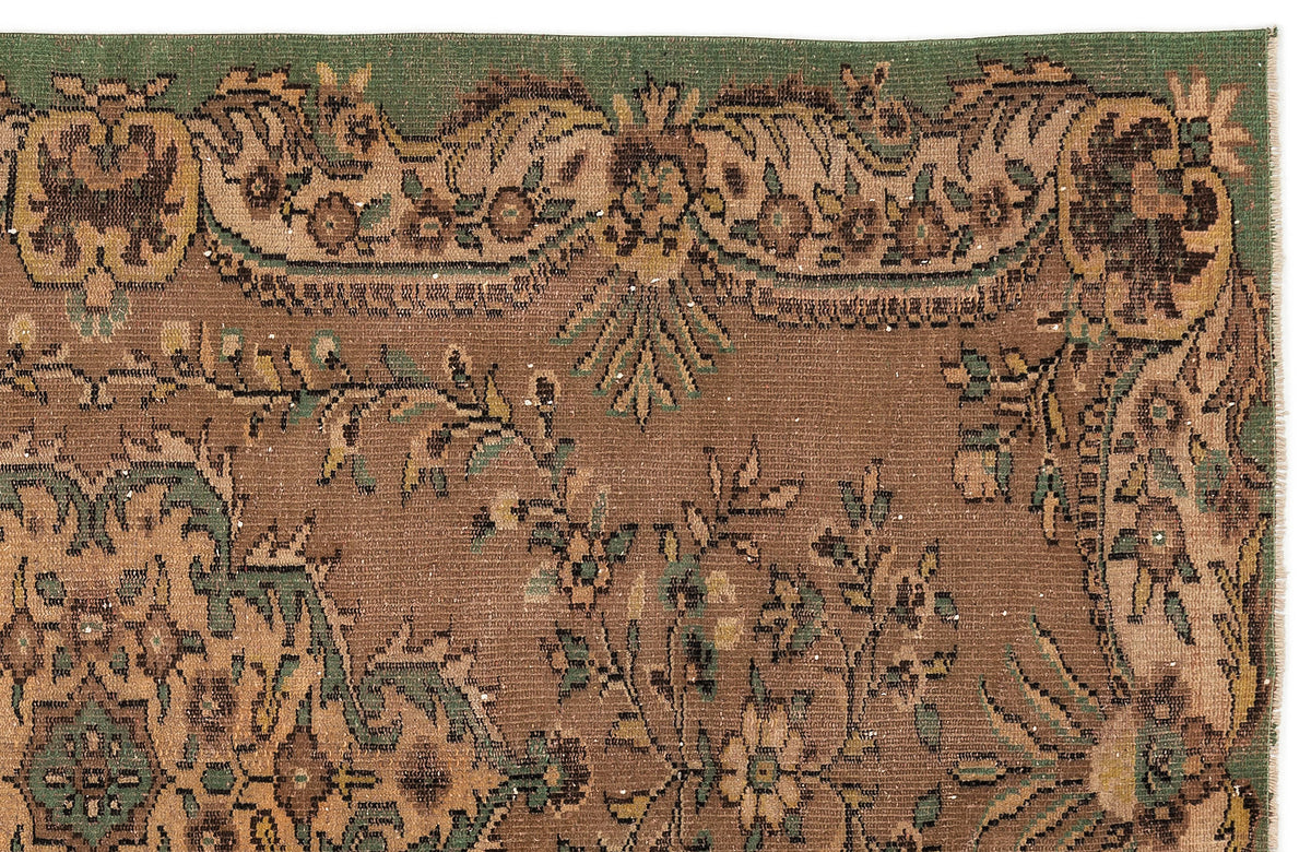 Brown and green traditional rug with a floral medallion border and intricate botanical motifs.