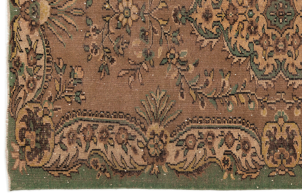 Brown traditional rug with a distressed floral medallion pattern in green, tan, and dark brown.