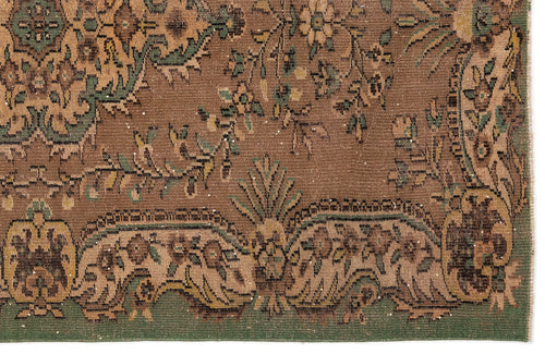 Load image 1 in gallery view. Brown and green traditional rug with a distressed floral pattern and ornate border.