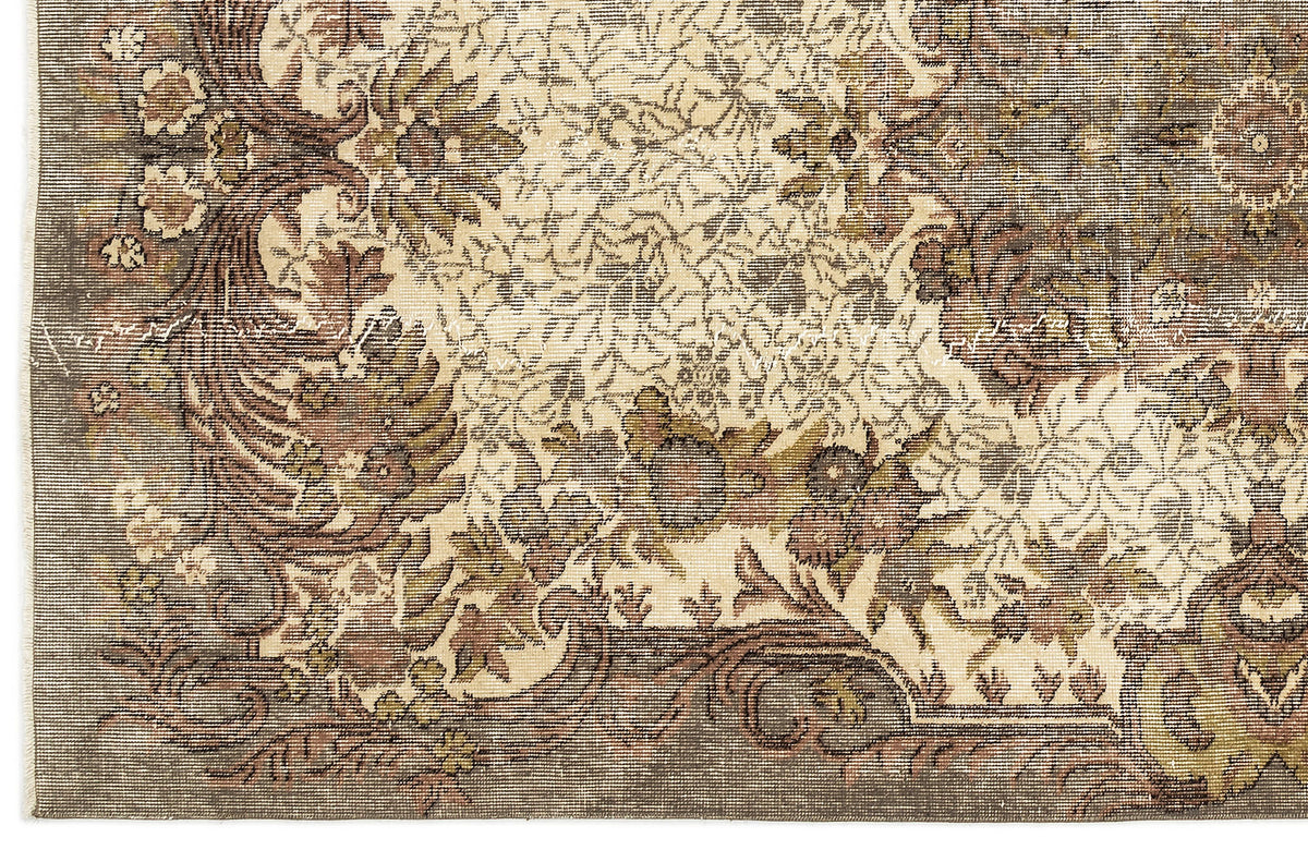 Distressed brown, olive, and cream rug with an intricate traditional floral medallion pattern.